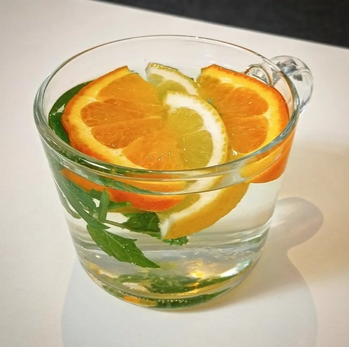 Kop verse muntthee met een schijfje citroen en sinaasappel